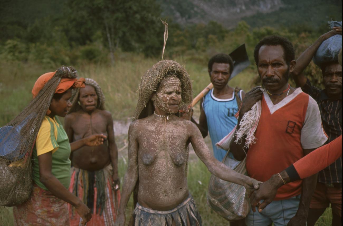 BD/166/166 - 
Woman with white spots (mud) is surrounded with people
