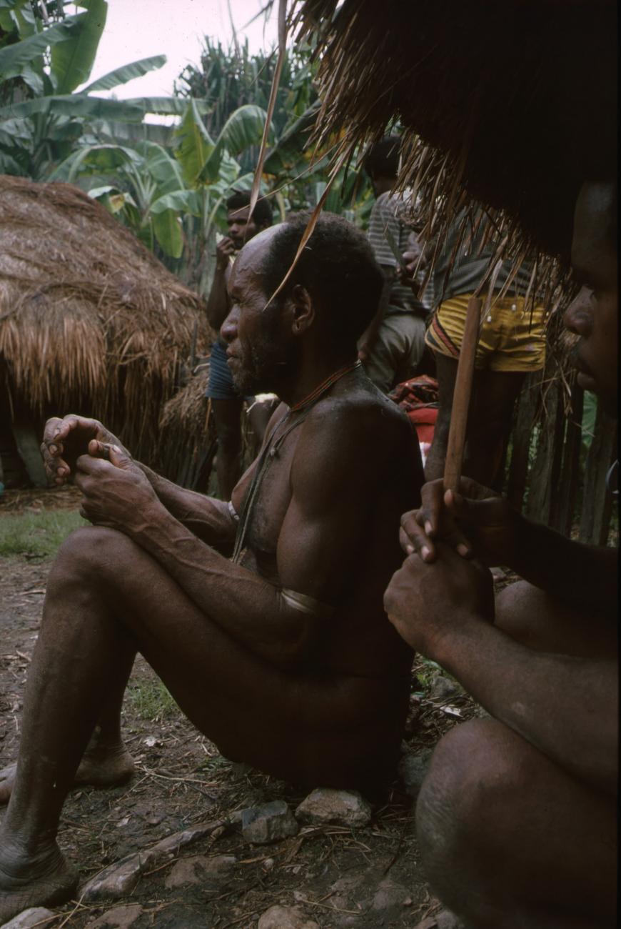 BD/166/79 - 
Man sitting on a row of stones 2
