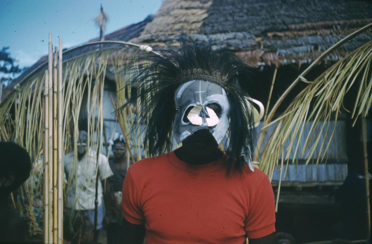 BD/209/3086 -
Man met masker en hoofdtooi