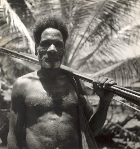 BD/245/12 -
Portret: Papua-man met bundel speren of pijlen.