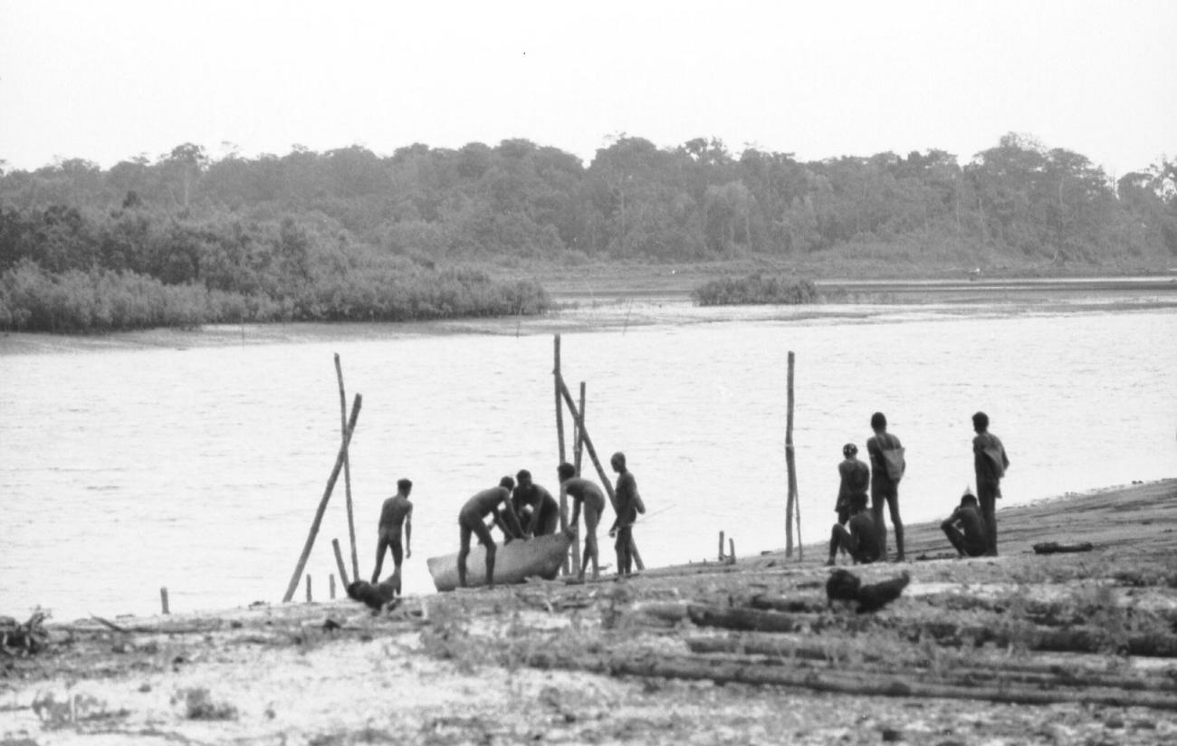 BD/133/65 -
Tocht Merauke-Kapi: Mannen met boot aan de rivier
