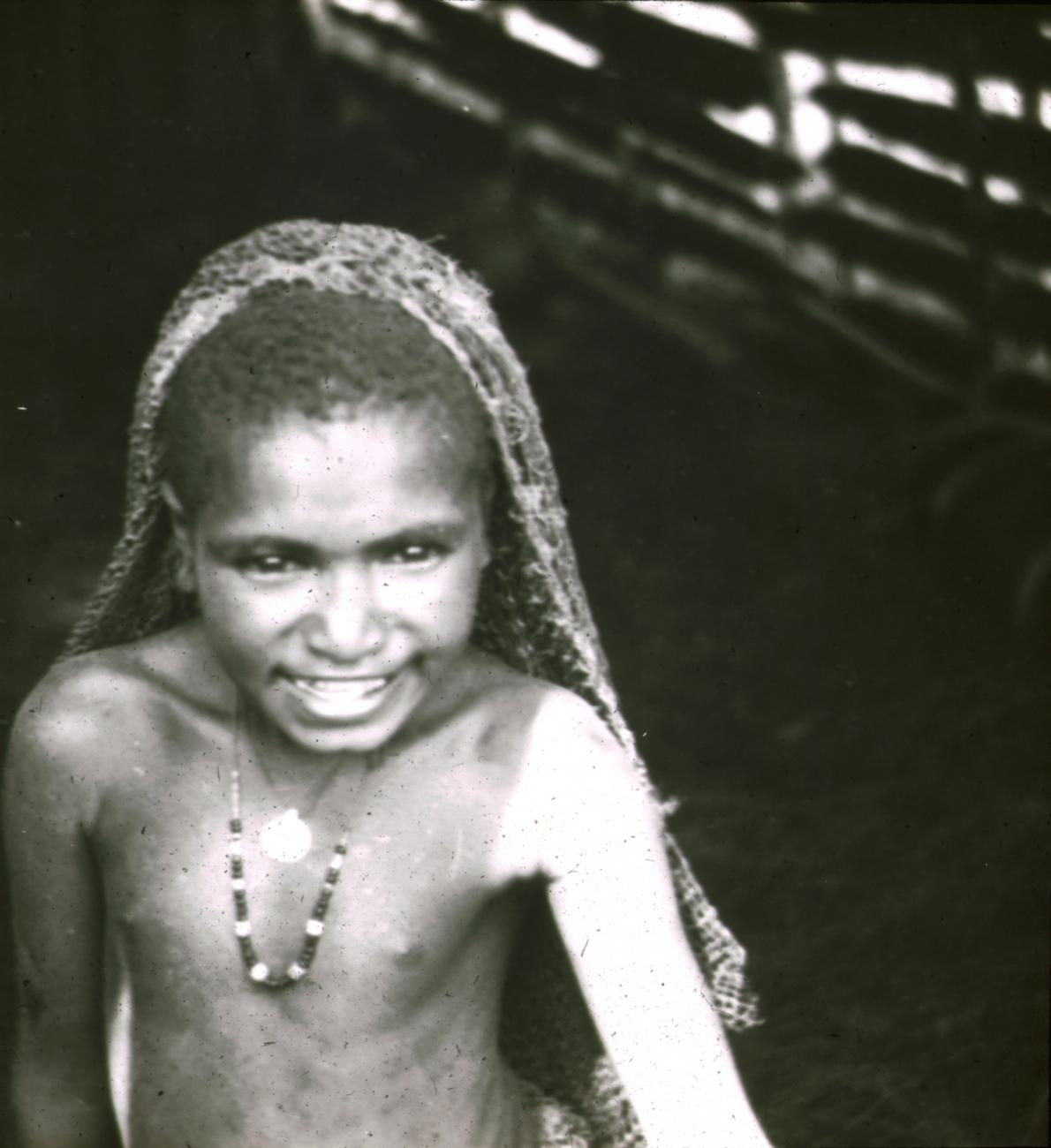 BD/329/29 - 
Papoea-meisje met halssieraden en draagnet
