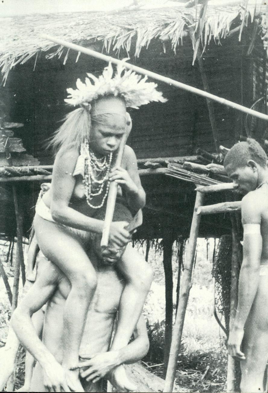 BD/40/57 - 
Een vrouw uit de Asmat op de schouders van een man
