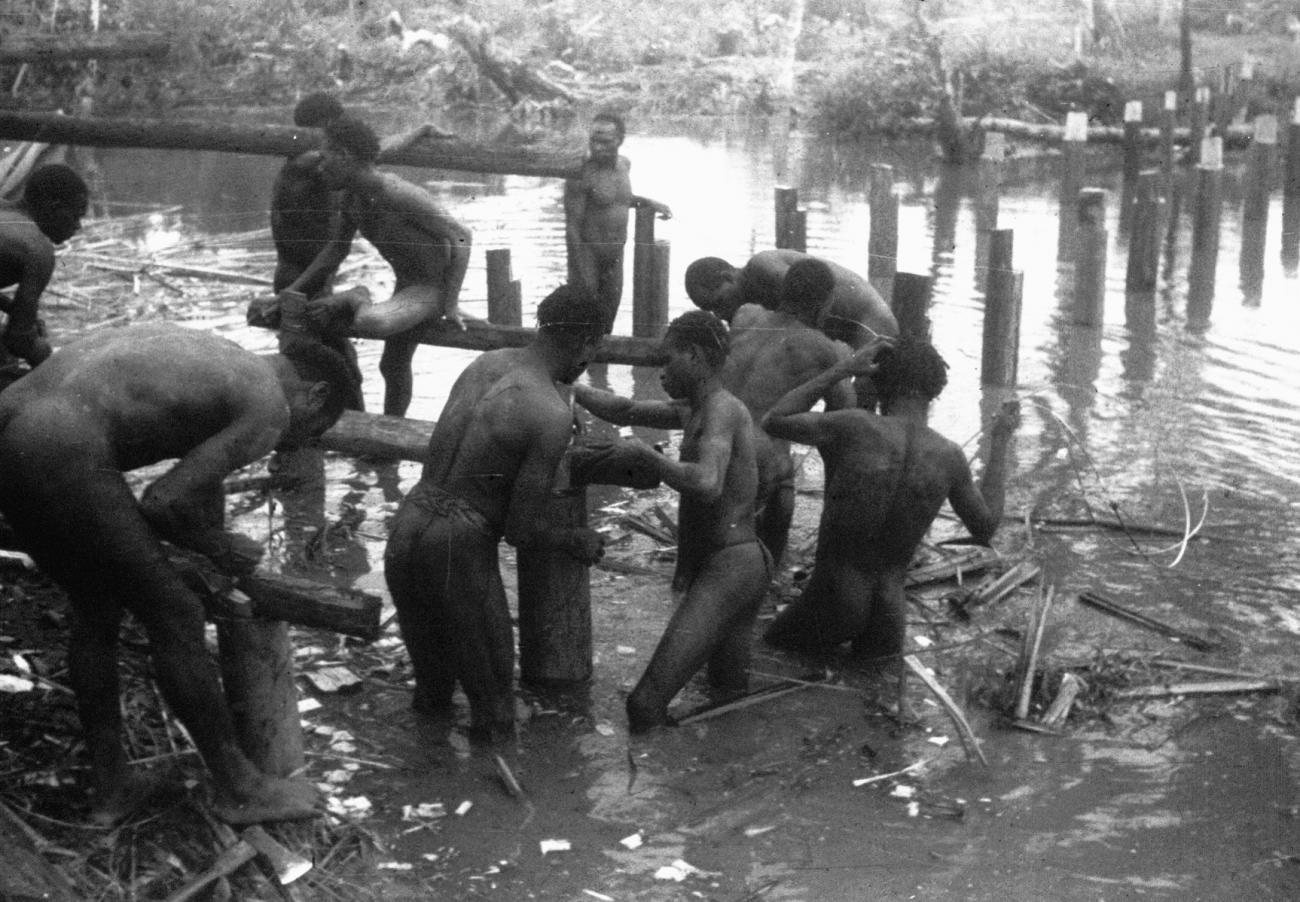 BD/216/117 -
Plaatsen van dwarsliggers voor de aanleg van een voetpad boven het water en modder