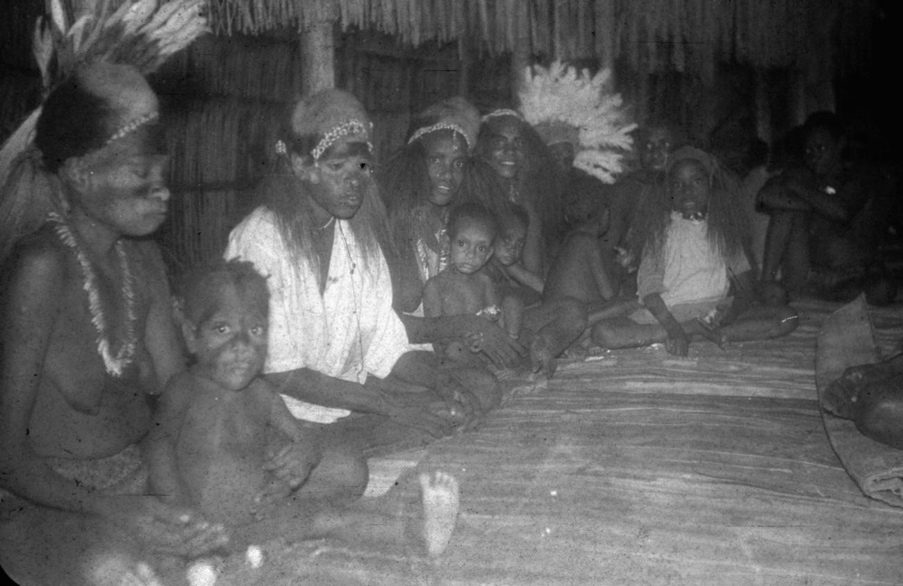 BD/216/134 -
Vrouwen met kinderen in hut met hoofdbedekking van couscous en veren