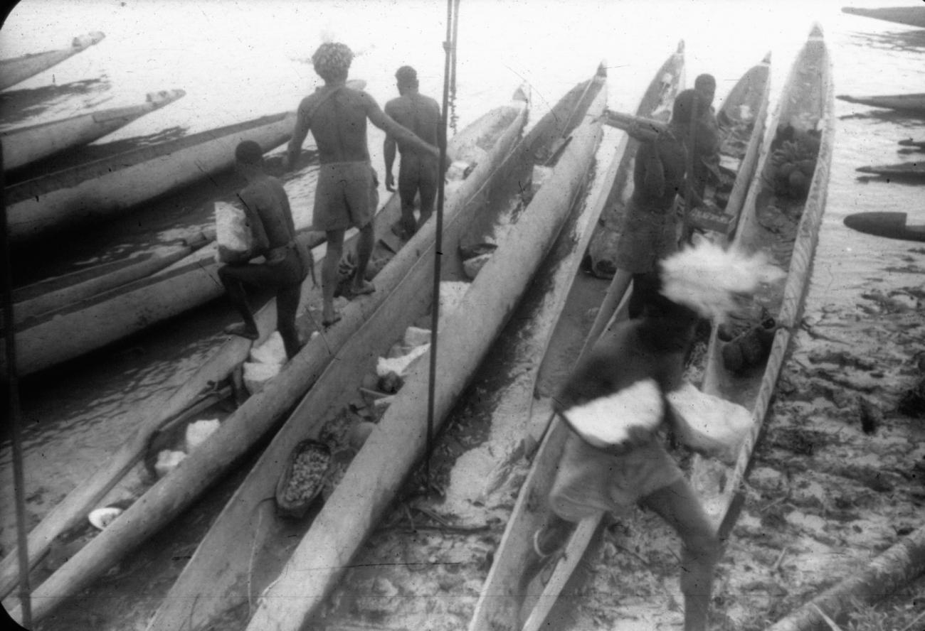 BD/216/147 -
Aanvoer en lossen van sago uit prauwen aan de rivieroever