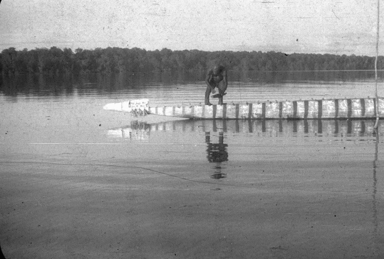 BD/216/189 -
Asmatter staand in een nieuwe prauw in de rivier
