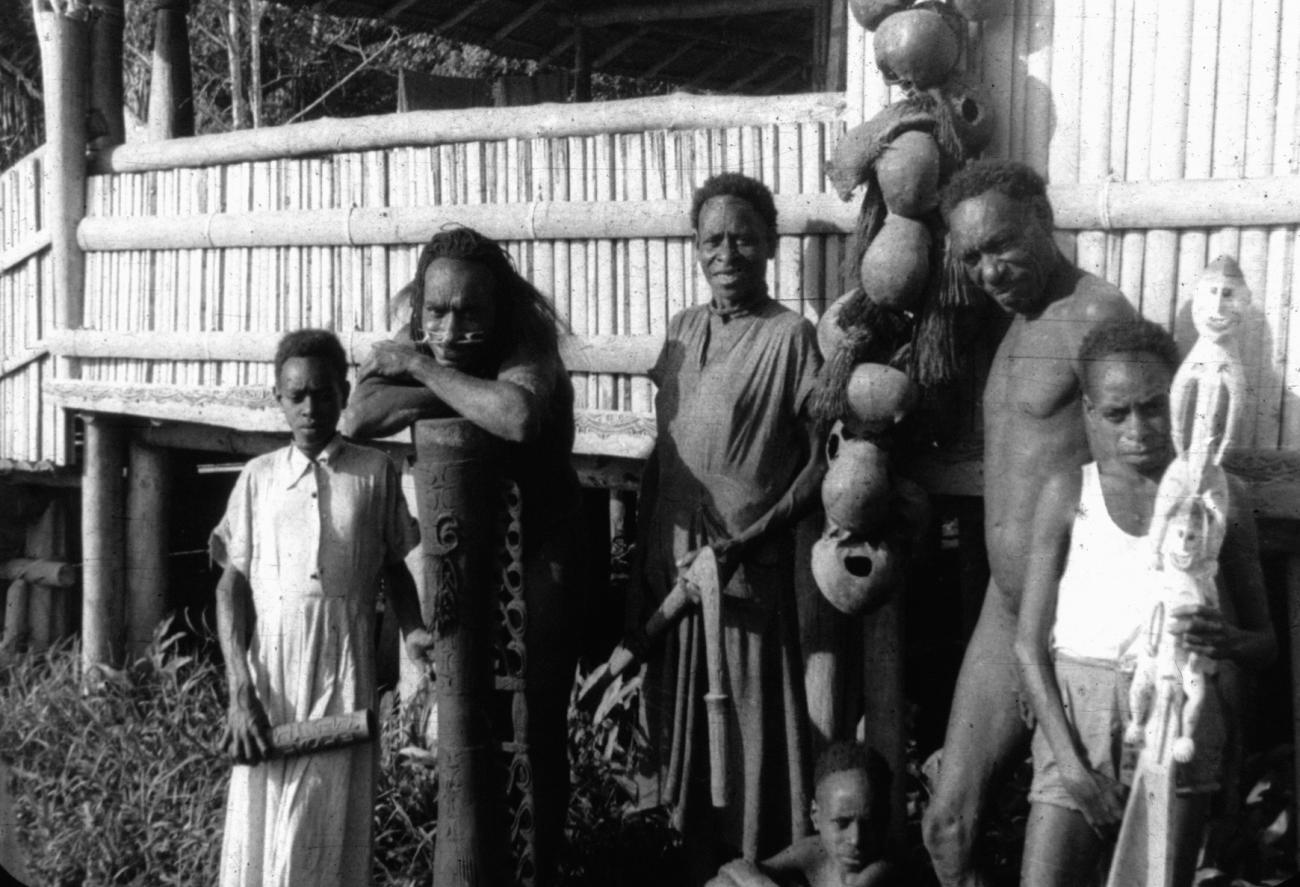 BD/216/202 -
Groep uit Asmat met voorouderprauw, schedels, sagokloppen,trom en snelhoorn