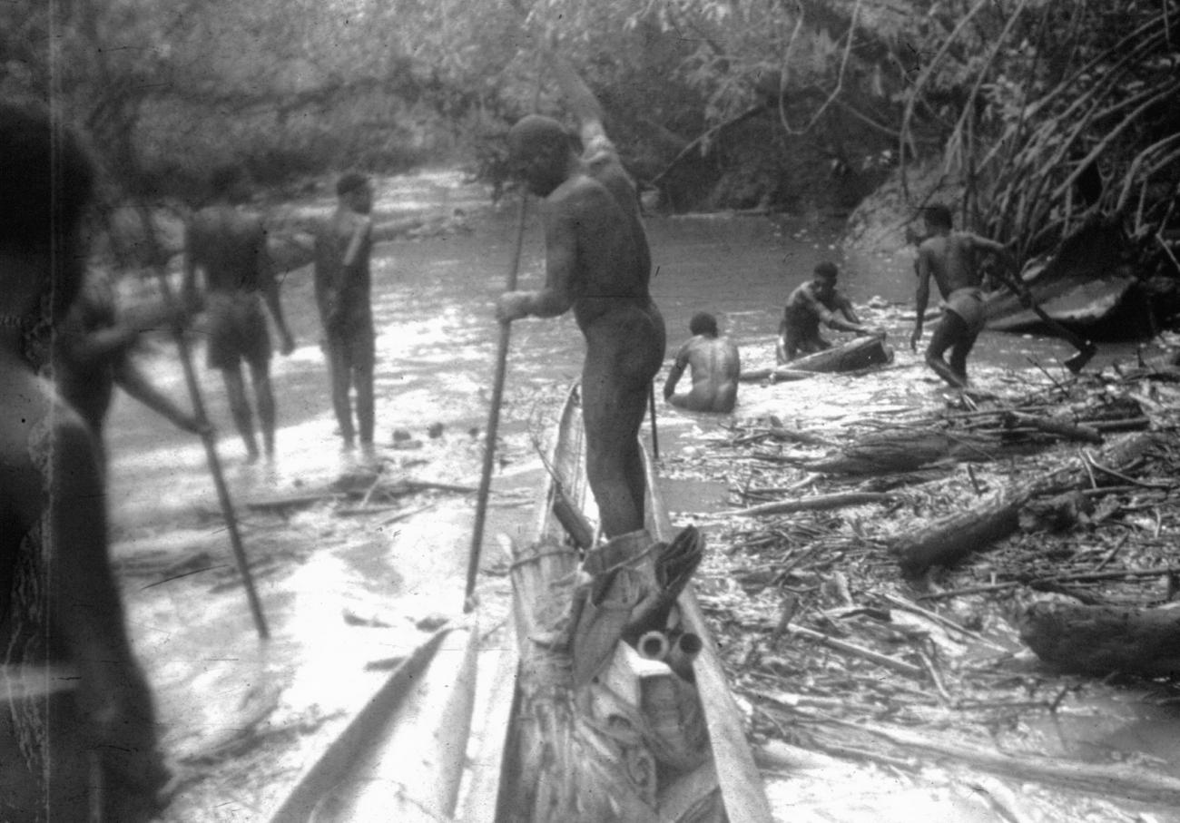 BD/216/236 -
Mannen maken doorgang voor de prauw op ondiep deel van de rivier