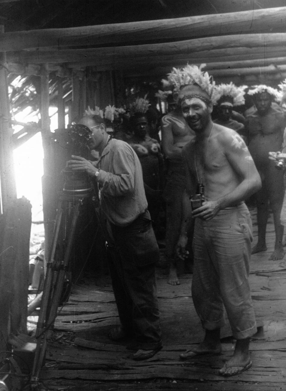 BD/216/270 -
Gilbert Sarthre filmt, terwijl Asmatmannen en Pierre Gaisseau met verentooi toekijken