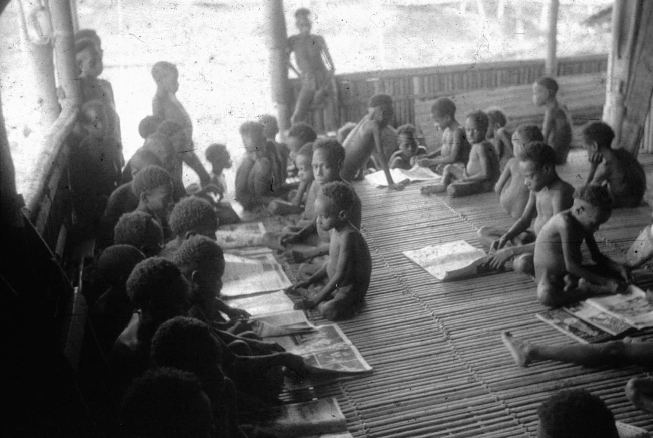 BD/216/302 -
Asmatkinderen bekijken kranten