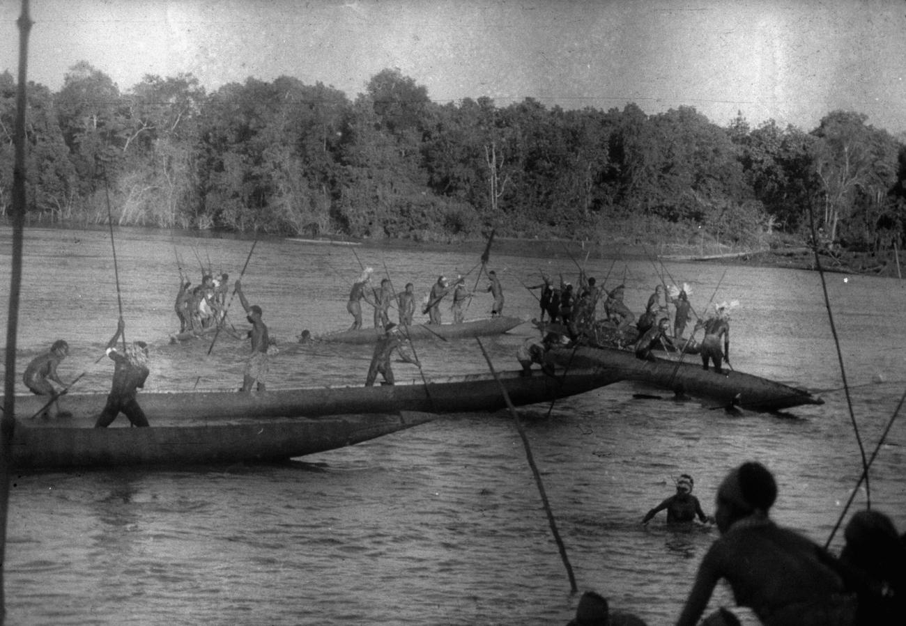 BD/216/49 -
Mannen uit de Asmat in en op de rivier met grote prauw