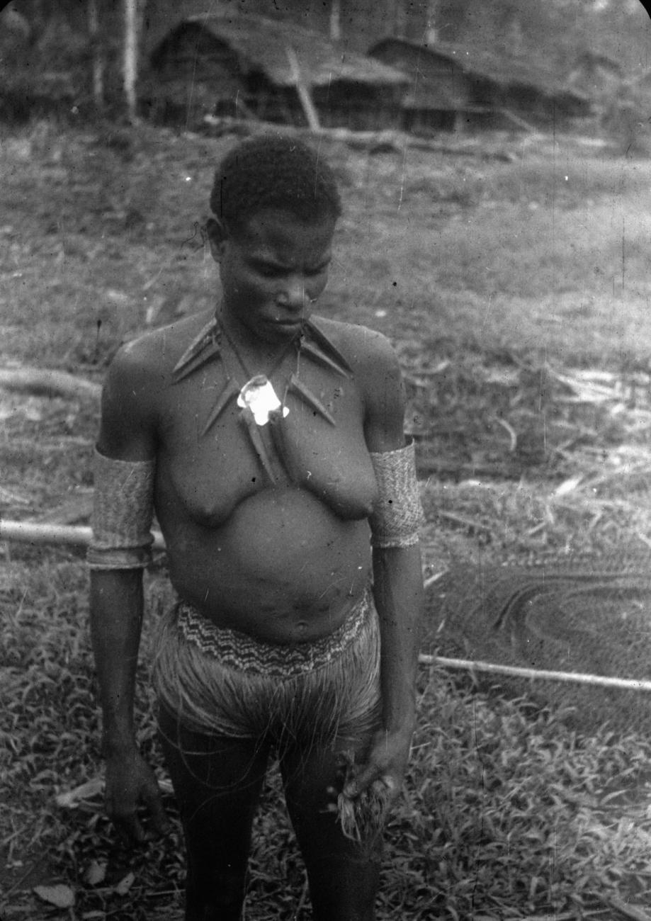 BD/216/84 -
Vrouw uit Asmat met ketting van varkenstanden en armbanden