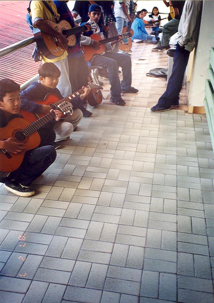 BD/269/108 -
Leerlingen spelen gitaar op een veranda in Tembagapura