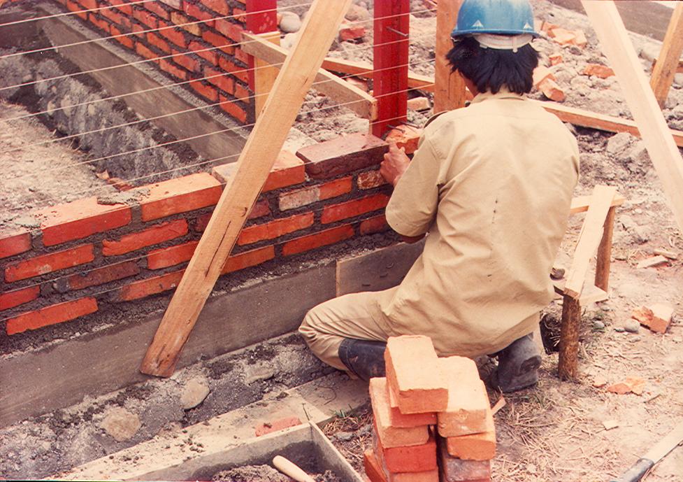 BD/269/128 -
Bouwvakker metselt een muur van het medisch centrum in Wamena