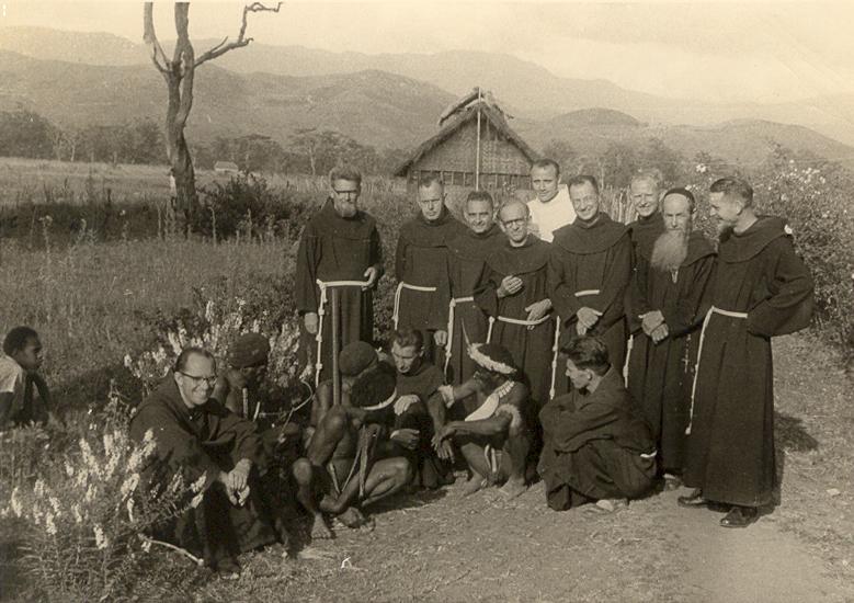 BD/269/23 -
Franciscanen met Dani-mannen tijdens retraite in Wamena, Baliem-vallei, op de achtergrond een mannenhuis?