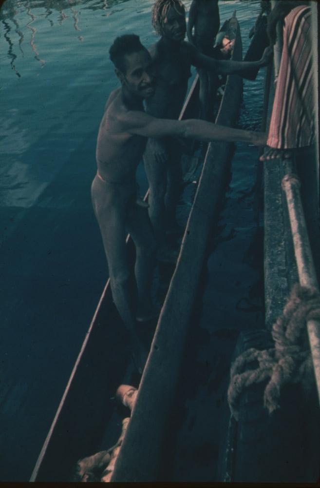 BD/30/2 - 
Asmat men in a prow supporting themselves on a patrol boat
