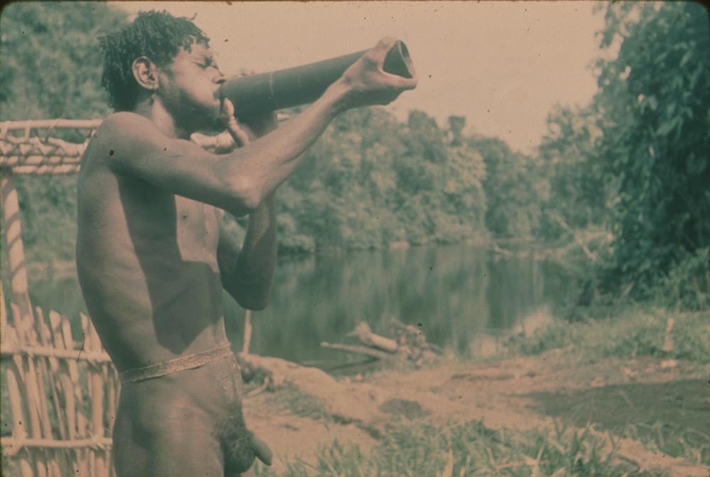 BD/30/43 - 
Asmatman blaast op snelhoorn bij rivier

