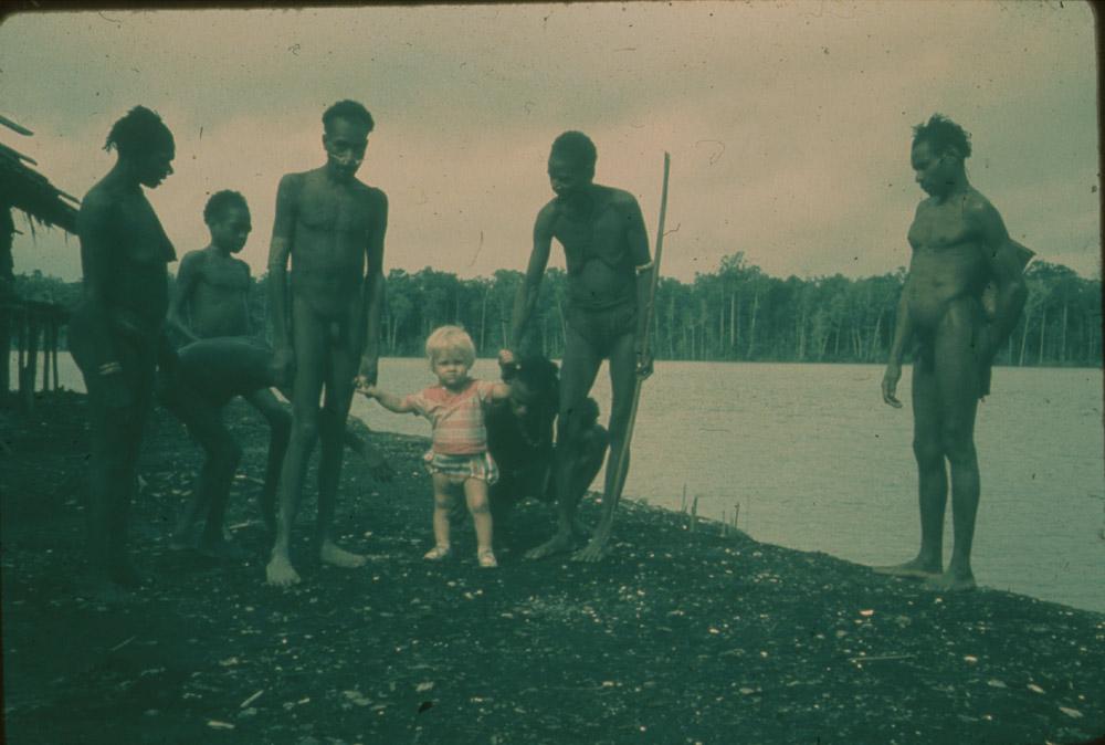 BD/30/59 -
Asmat women and men with a small white child at the river shore