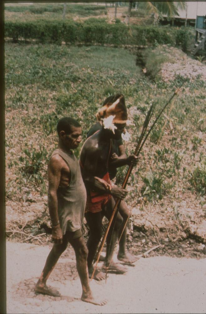 BD/30/73 -
Asmat men walking on the street in the village
