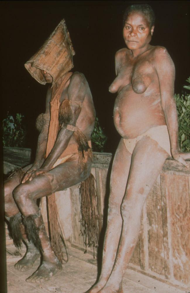 BD/30/74 - 
Asmat women in mourning cloths sitting on a veranda at night
