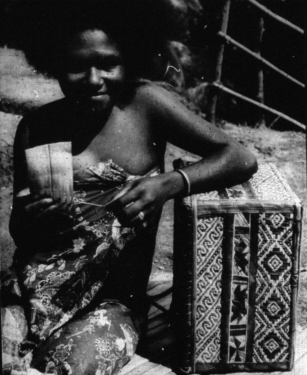 BD/66/148 -
Jonge vrouw uit Japen met een gevlochten doos vam palmbladeren (kabilla)