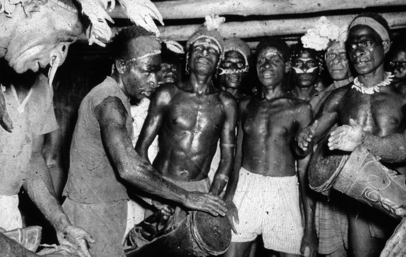 BD/66/184 -
Asmat, mannen met trommels in het mannenhuis