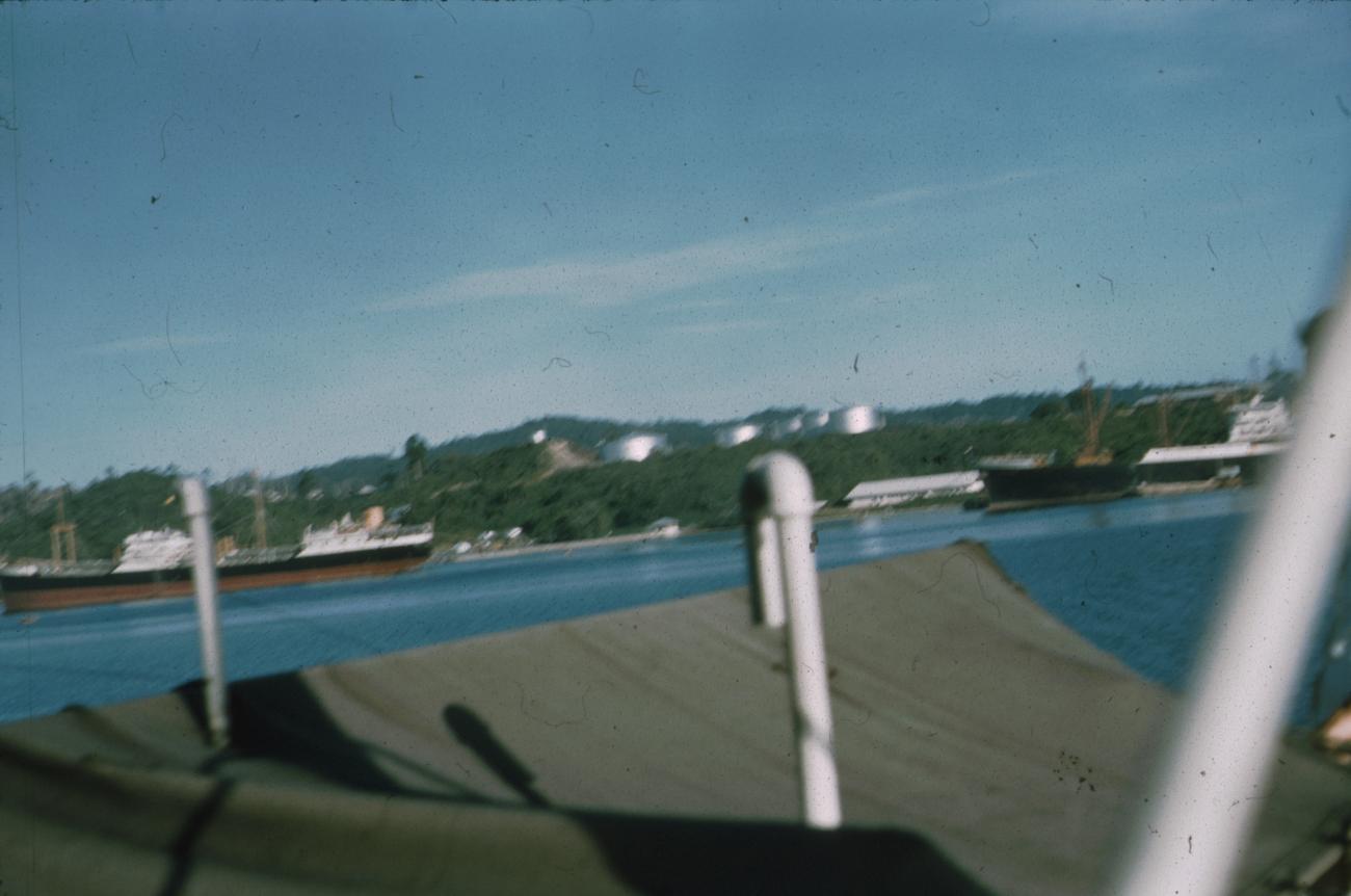 BD/171/678 -
Foto kust vanaf schip; aangemeerde schepen en oliereservoirs.