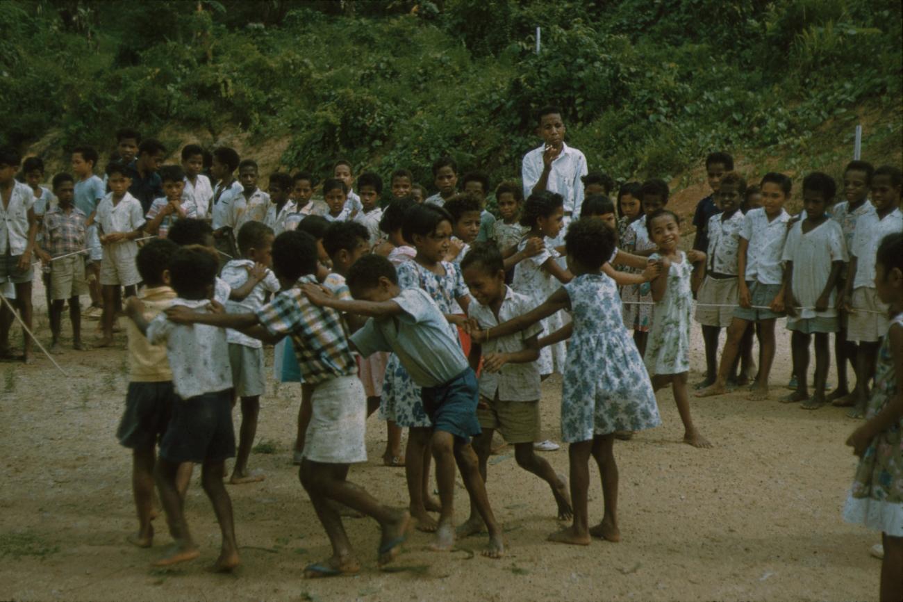 BD/171/707 -
Kinderen doen de polonaise met leraar erbij