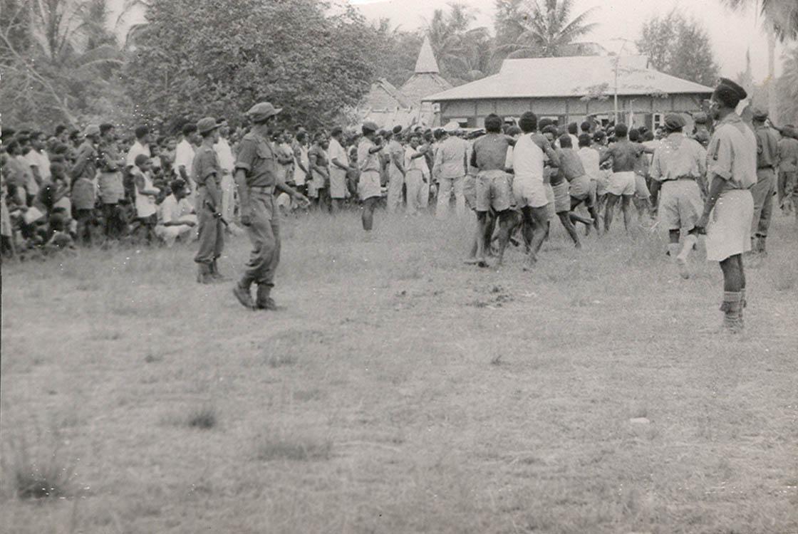 BD/269/1186 - 
Omstanders en deelnemers bij het afscheid van gouverneur  J. van Baal in Kokonau
