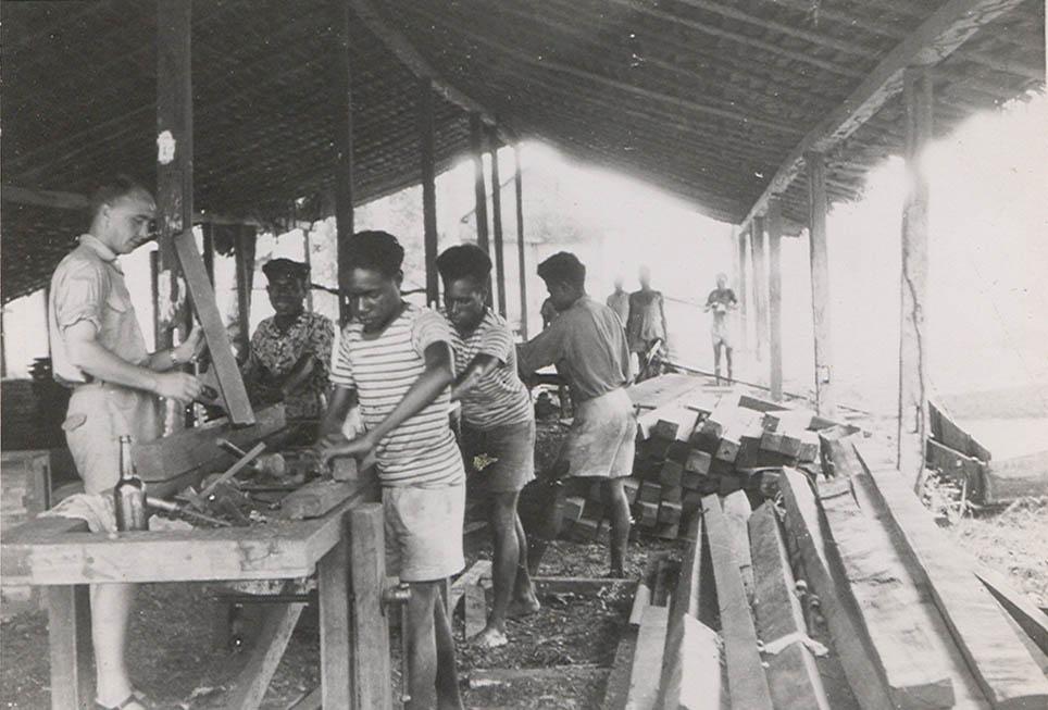 BD/269/1195 - 
Franciscaans broeder Henk Blom aan de slag met praktijkleerlingen in de timmerwerkplaats in Kokonau
