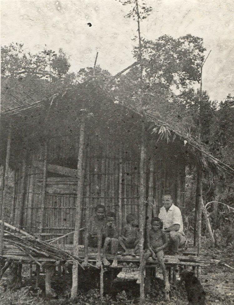 BD/269/1241 -
Franciskaner broeder Henk Blom poserend met kinderen voor een huis in Enarotali