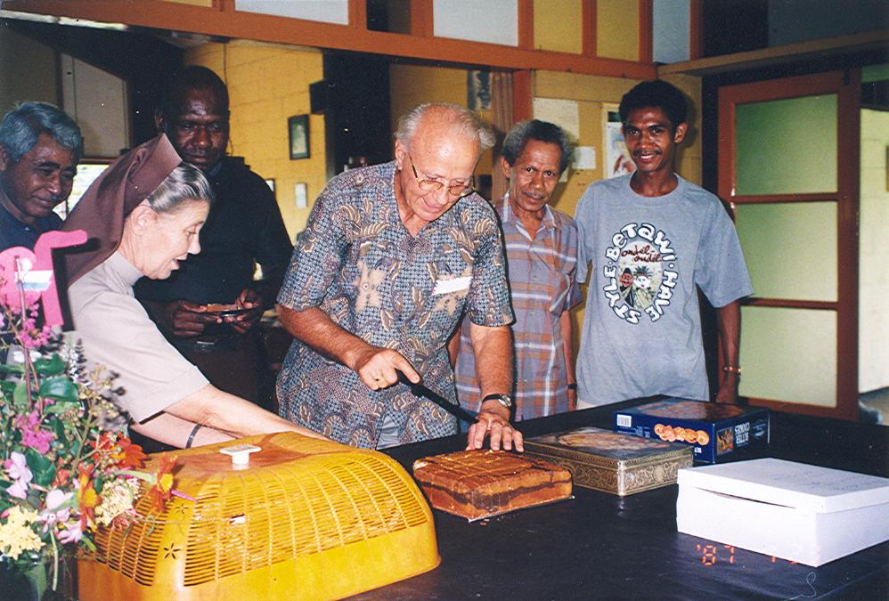 BD/269/795 - 
Aansnijden taart of cake in bijzijn van zuster en Papoeas
